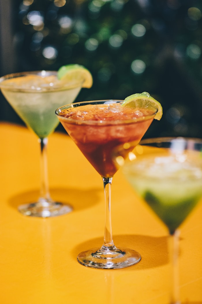 Tres cócteles de colores servidos en copas martini